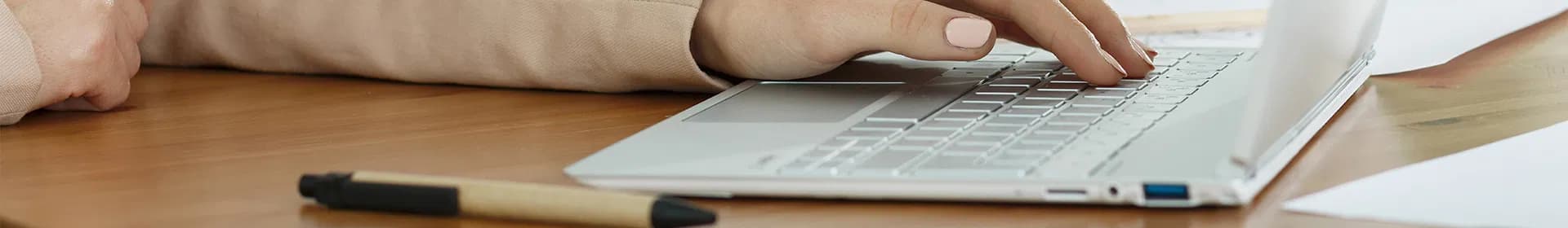 Hands typing on a laptop keyboard